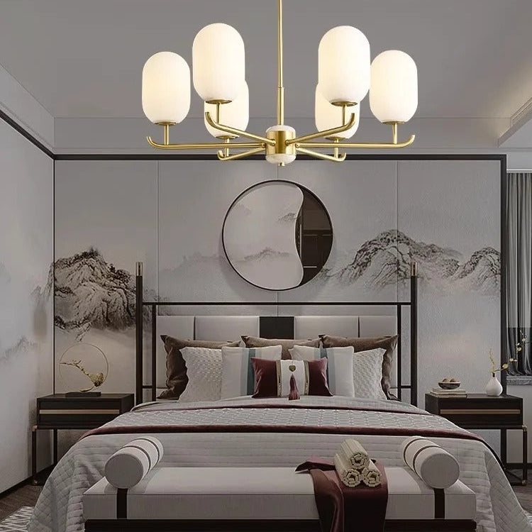 Gold multi-arm chandelier with white glass globe shades over a bedroom ceiling
