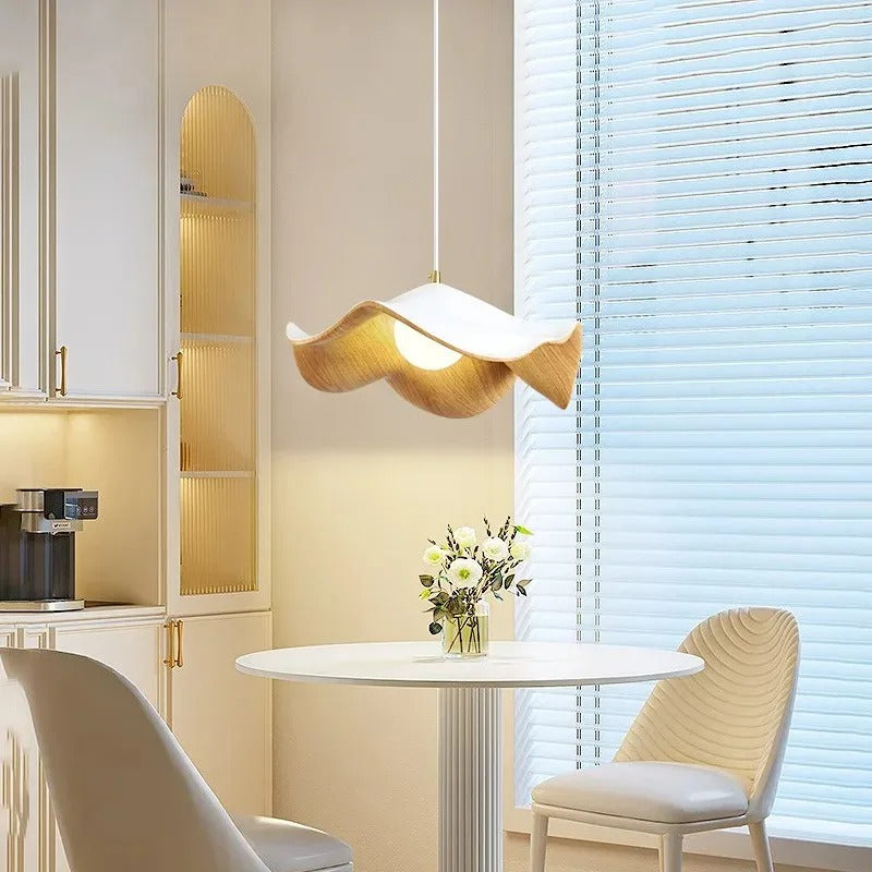 Brown curved petal pendant light hanging over dining area