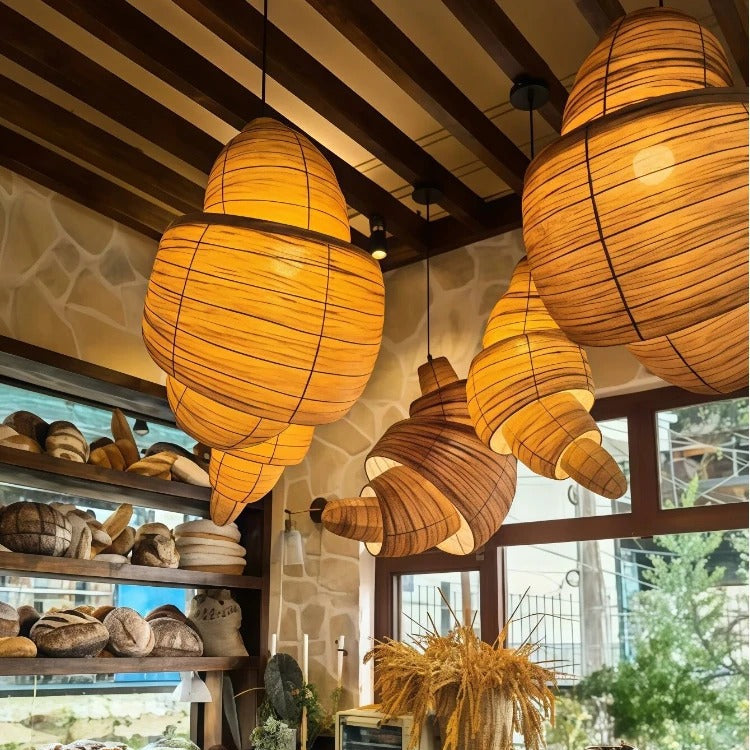 Set of brown woven layered pendant lights with rounded, horn-style shades under ceiling