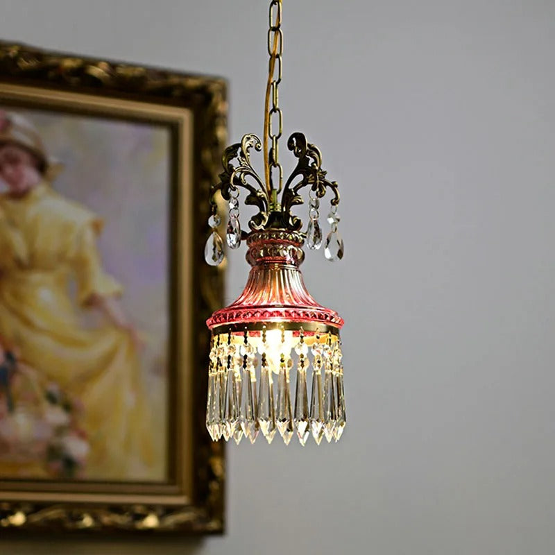 Crystal pendant light with red metal shade, gold chain, and hanging crystal drops