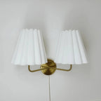 White pleated twin lamp shades with gold-tone curved mounting bar
