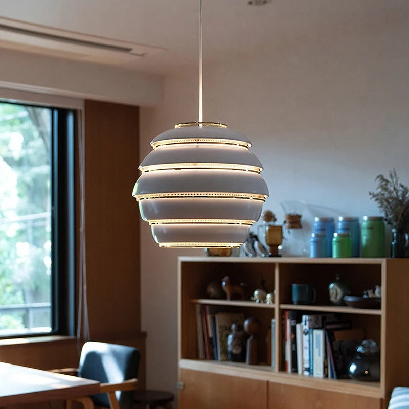 Layered beehive pendant light with white frosted bands and gold trim, hanging from cord