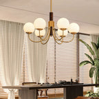 Ceiling-mounted multi-arm globe chandelier with brass arms and frosted glass bulbs