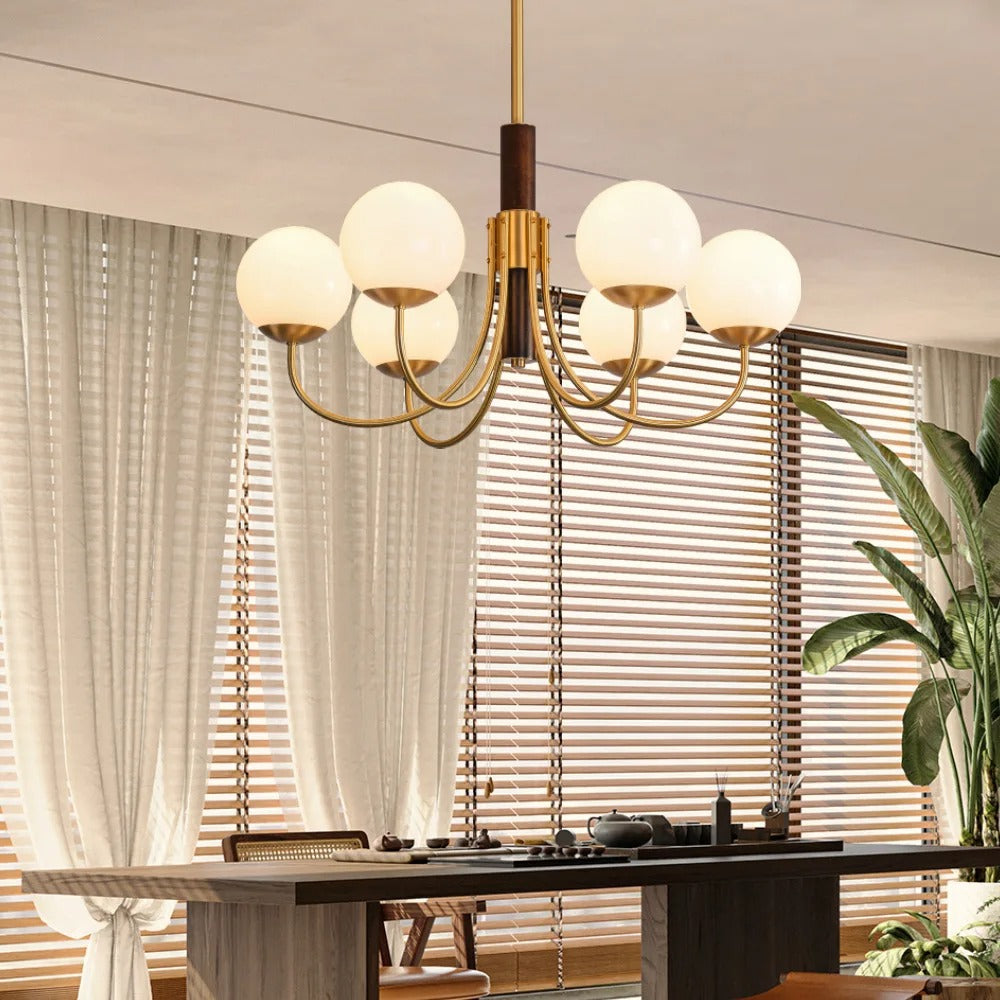 Ceiling-mounted multi-arm globe chandelier with brass arms and frosted glass bulbs