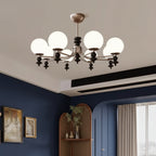 Multi-arm globe chandelier with five white glass shades and dark black finials, arched arms