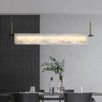 Rectangular linear alabaster bar chandelier with glowing white diffuser over dining table