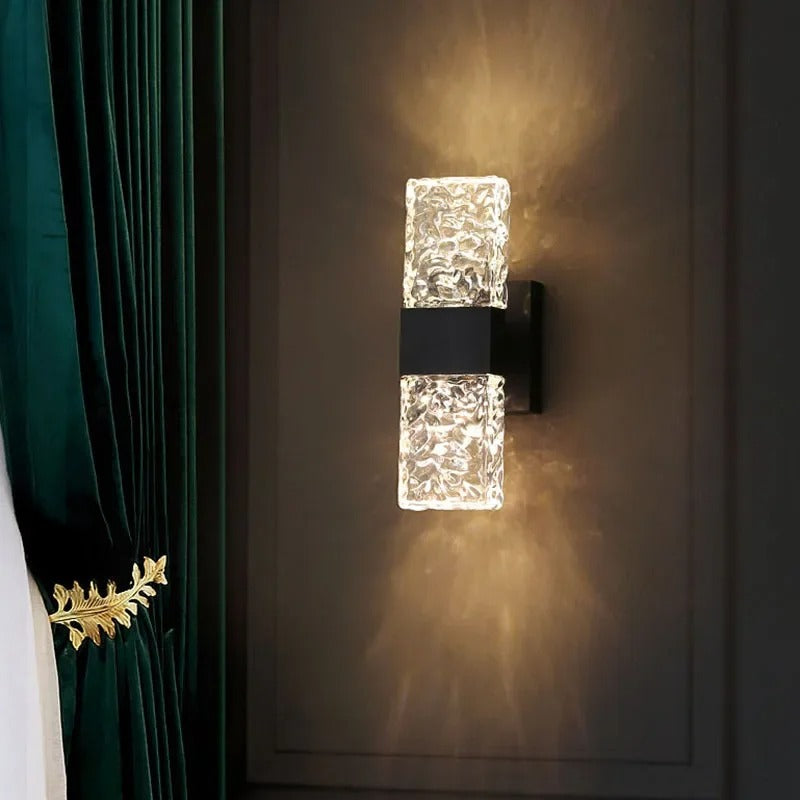 Rectangular wall light with textured water-ripple glass panels, warm amber glow.