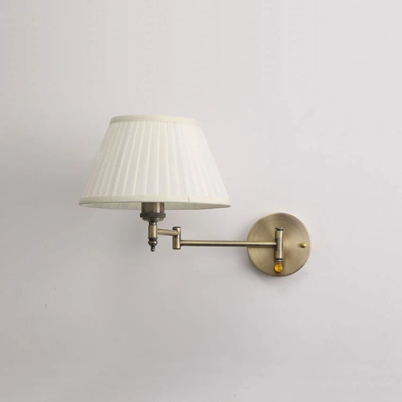 Brass wall sconce with fabric drum shade and swing arm on round wall plate