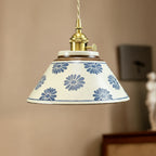 Ceramic conical pendant light with blue floral pattern shade and brass pull-cord fitting