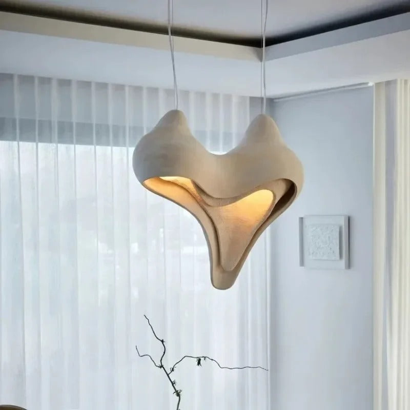 Heart conch pendant light suspended with warm glowing interior, white conch shade