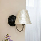 Capiz shell conical wall light with matte black base and translucent conical capiz shade