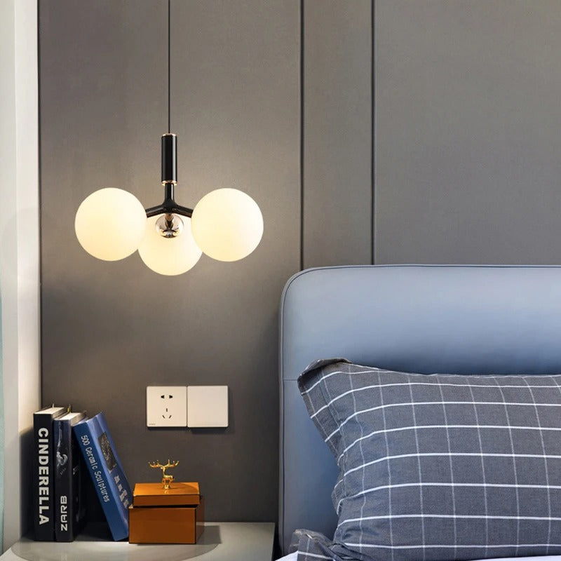 Black globe pendant light with three round glass shades and chrome mounting