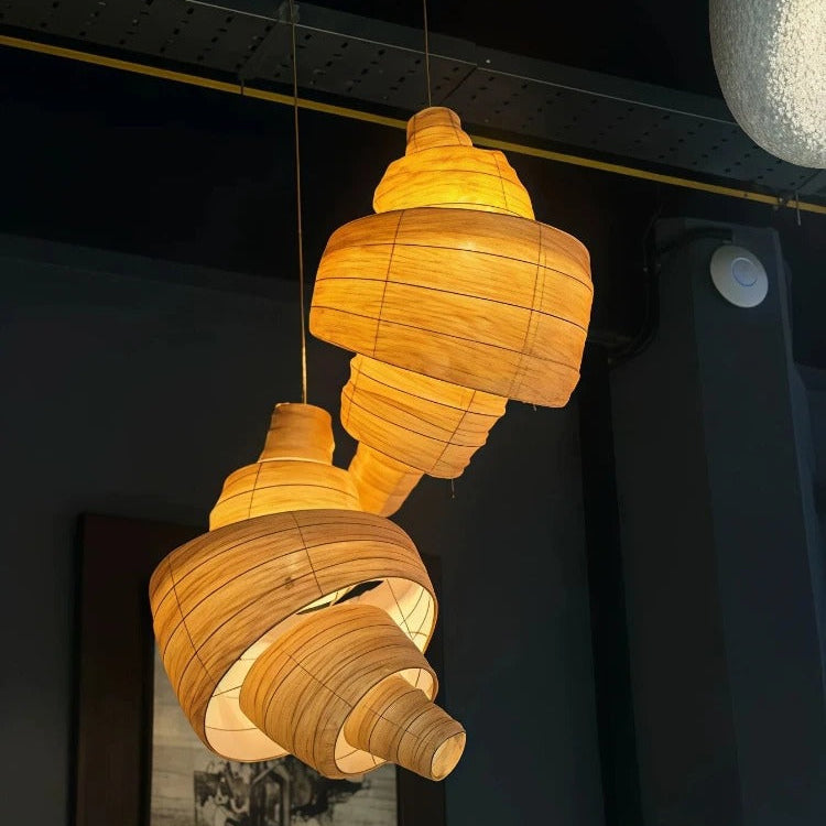 Brown woven layered pendant light with warm lit glow and curved horn-style shade