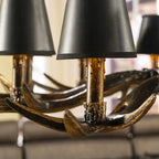 Close-up antler chandelier base with bronze tone and matte black bell shade