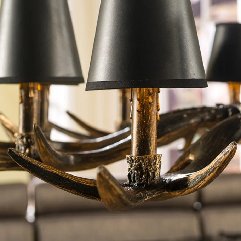 Close-up antler chandelier base with bronze tone and matte black bell shade