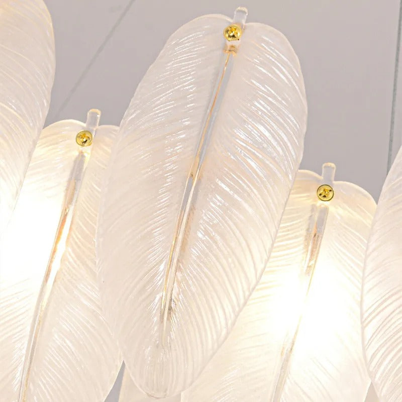 Close-up of white feather glass shades with gold-capped stems on a hanging chandelier