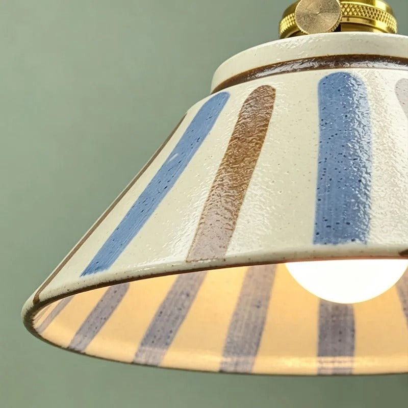 Close-up ceramic wall light shade with textured white finish and blue-and-beige stripes