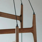 Close-up of walnut wood support bars and black hanging cords for globe chandelier