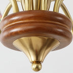 Gold-tone finial on turned wood chandelier stem with brass cap