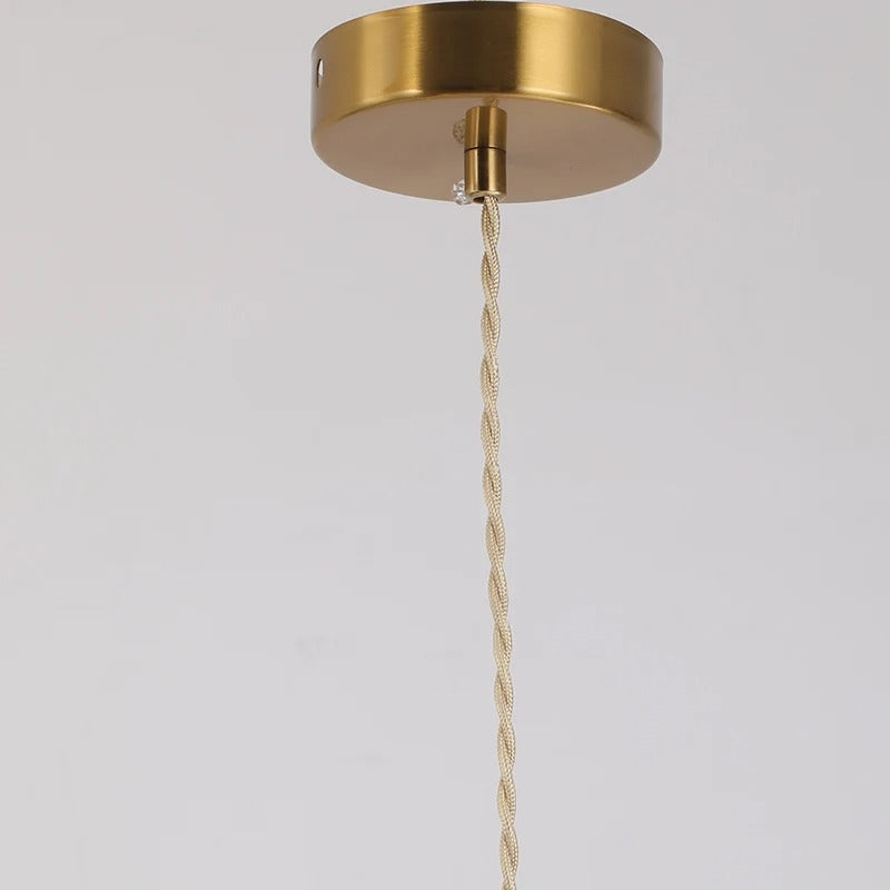 Brass pendant light ceiling cap with twisted cord hanging down