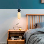 Stacked glass cylinder pendant light with black top and frosted opal shade