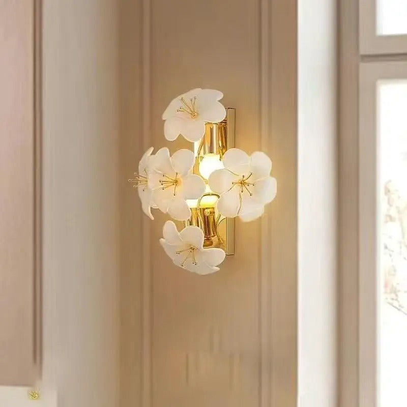 Wall sconce botanical light with gold stem and glowing flower petal shades