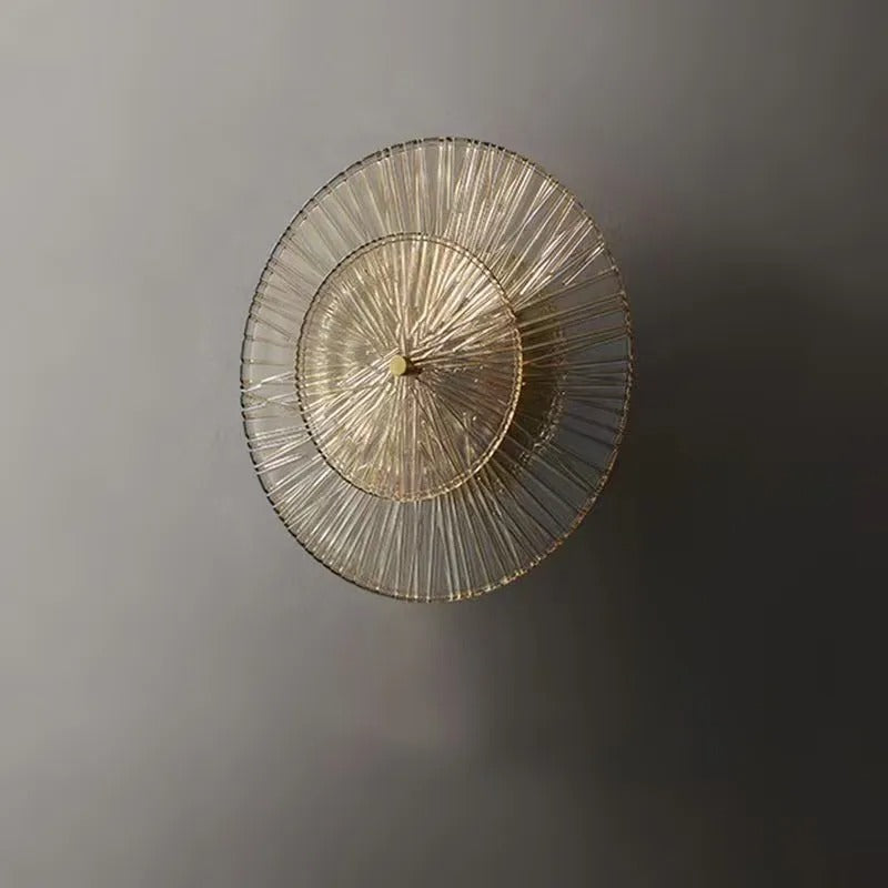 Circular tiered glass wall light, soft unlit look with gold-toned center cap