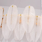 Row of white feather-glass shades with gold finials on linear hanging chandelier