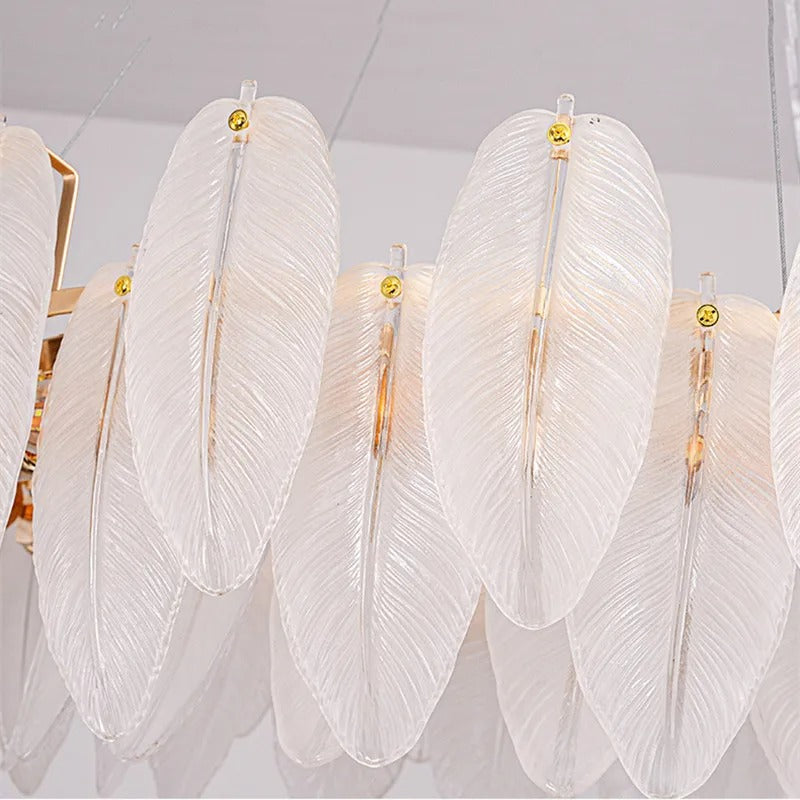Row of white feather-glass shades with gold finials on linear hanging chandelier