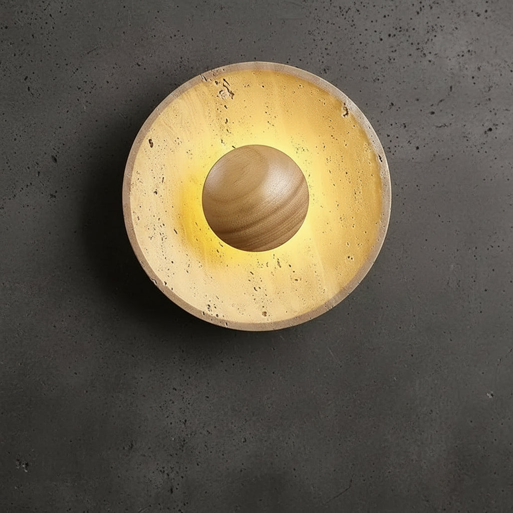 Single round backlit wall sconce with speckled tan travertine disc and dark insert