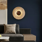 Round backlit wall sconce with textured tan disc and dark circular center