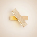 Long bar wall sconce with speckled travertine panel and light wood backplate
