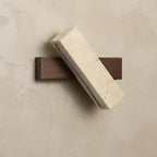 Rotatable long bar wall sconce with speckled travertine diffuser and dark wood backplate