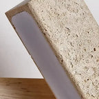 Close-up of speckled travertine bar wall sconce diffuser with warm LED strip