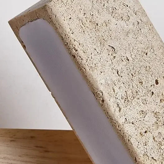 Close-up of speckled travertine bar wall sconce diffuser with warm LED strip