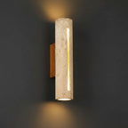 Beri travertine tubular wall light with vertical slot, warm glowing cylinder sconce