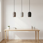 Concrete cylindrical pendant light set with speckled gray and black shades and black cords
