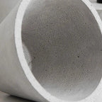 Concrete pendant light shade close-up with speckled gray texture and white rim