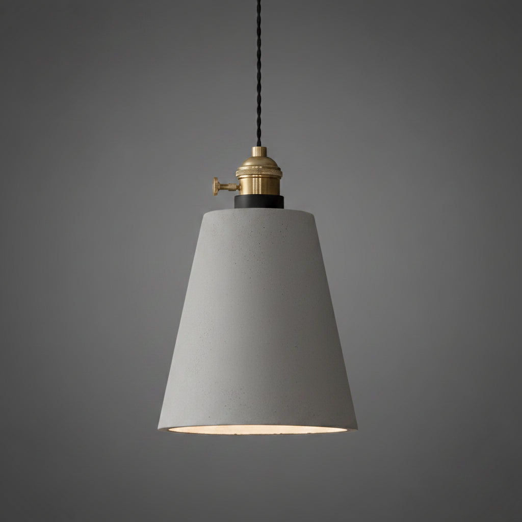 Concrete pendant light with speckled light-gray cone shade and brass socket on cord