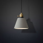 Concrete pendant light with light-gray cone shade and brass socket, hanging on black cord