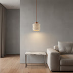 Ribbed travertine pendant light with warm-lit cylindrical travertine shade