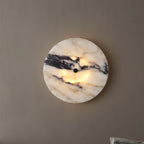 Circular marble wall light with warm center glow and black mount