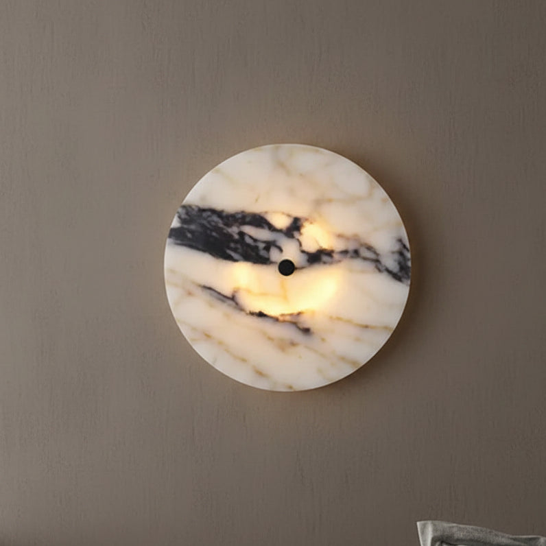 Circular marble wall light with warm center glow and black mount