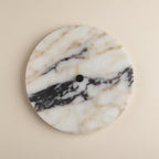 Round marble wall light disc with black center mount and warm inner glow