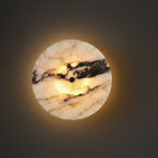 Circular marble wall sconce with warm light, black center mount on stone disc
