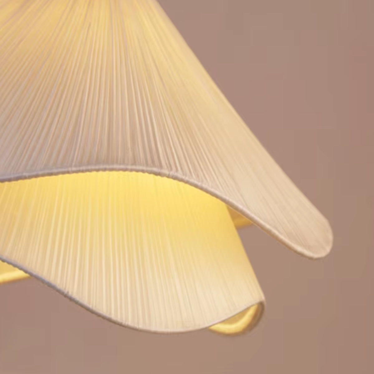 Warm-lit off-white pleated fabric petal shade for a flower pendant light
