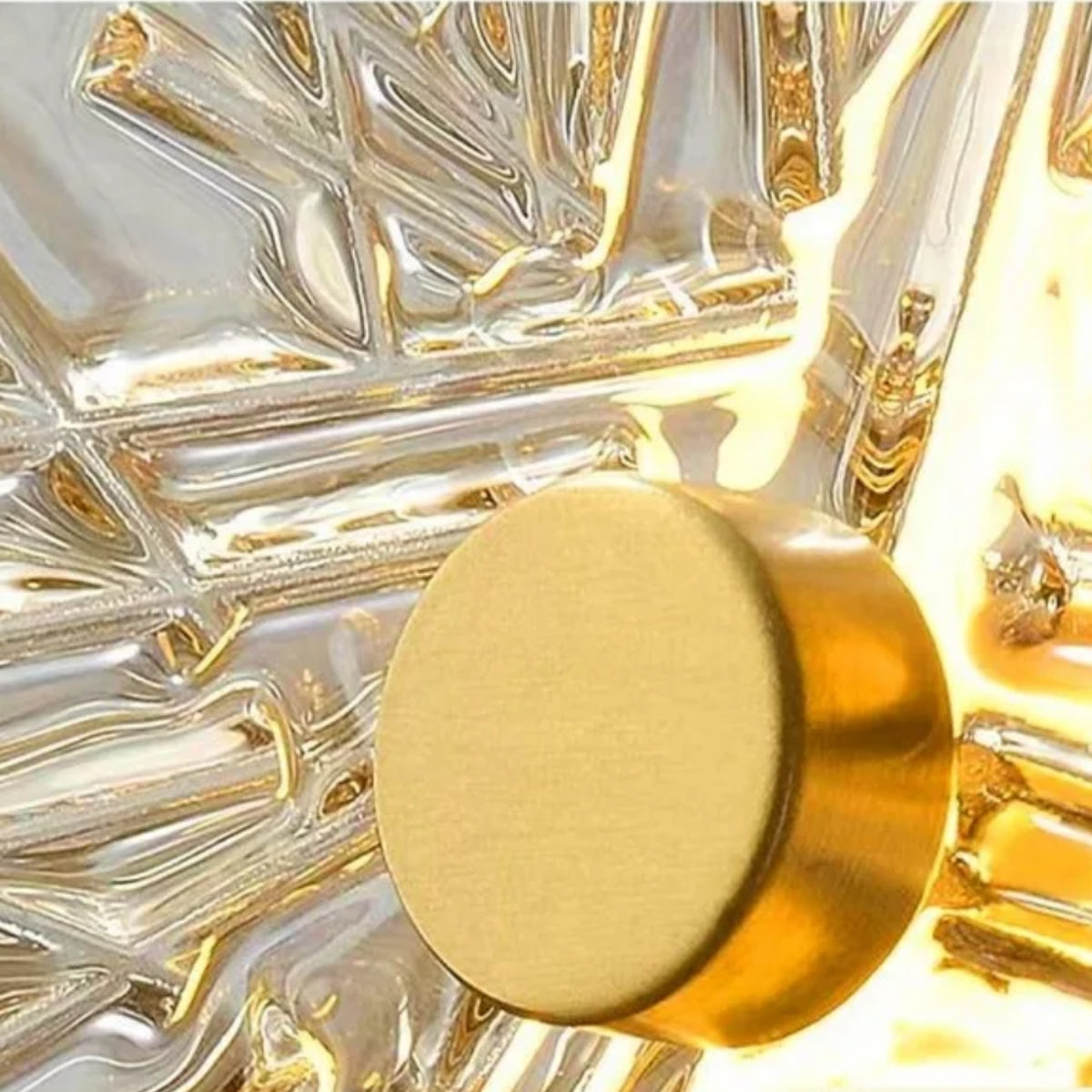 Close-up of tiered circular glass wall light housing with warm lit bulb center