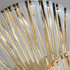 Close-up of glass rod tiers on circular wall light with gold-toned accents