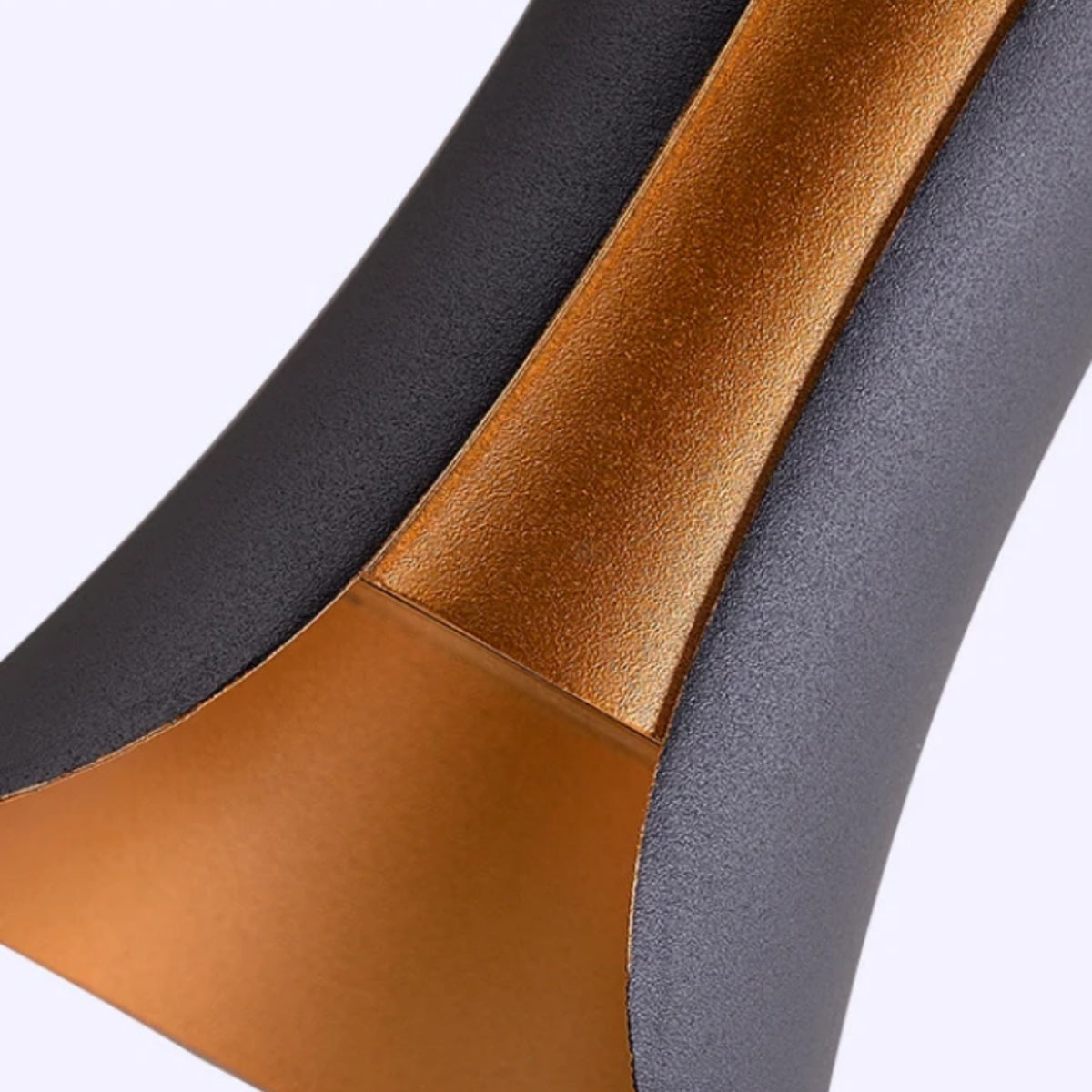 Wall light close-up with black housing and textured gold inner bezel