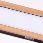 Close-up of horizontal LED tube inside light wood arm for wall light